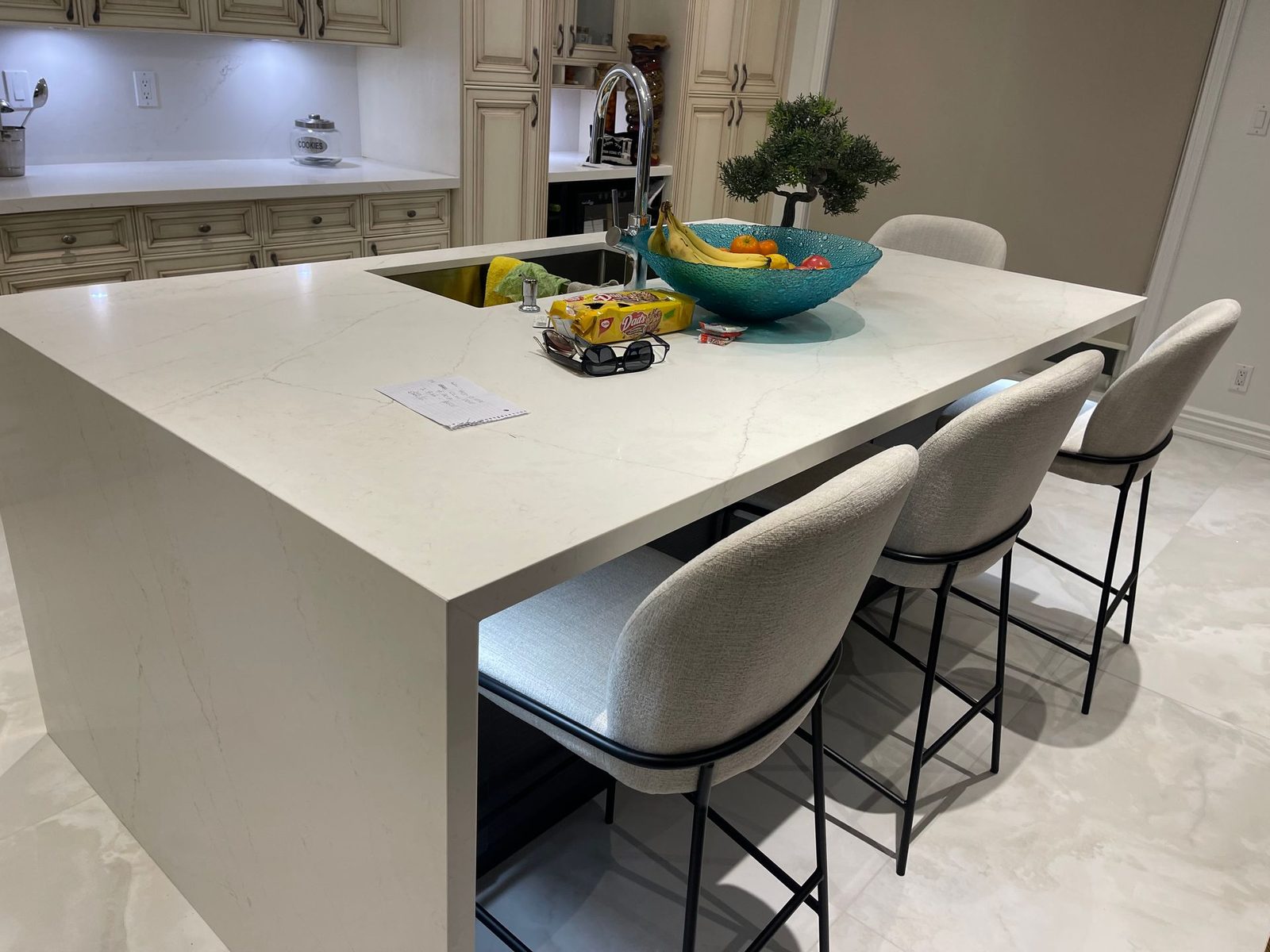 Custom kitchen island with waterfall counter and counter stools